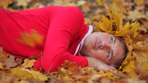 sonbahar yaprakları üzerinde yatan adam - Video, Çekim