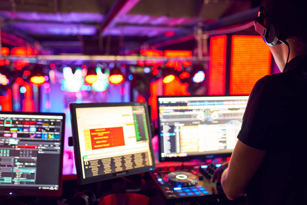 DJ mixy toru w nocnym klubie, na imprezie. w laser light show w tle - Zdjęcie, obraz