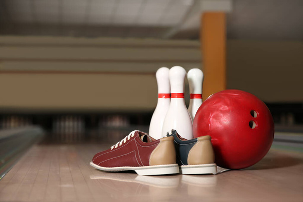 Shoes, pins and ball on bowling lane in club - Photo, image