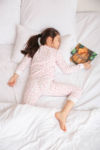 Aranyos kis ázsiai lány alszik az ágyban - Fotó, kép