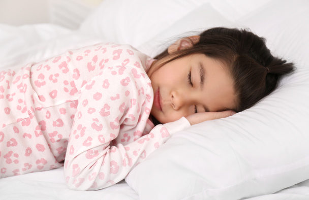 schattig klein aziatisch meisje slapen in bed - Foto, afbeelding