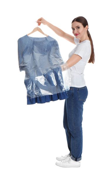 Young woman holding hanger with dress on white background. Dry-cleaning service - Photo, Image