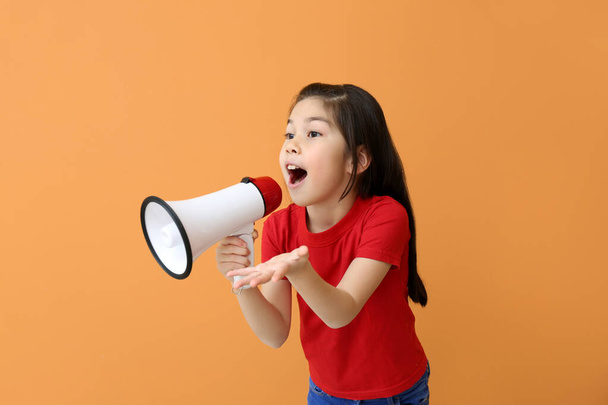 Cute little girl with megaphone on color background - Photo, image