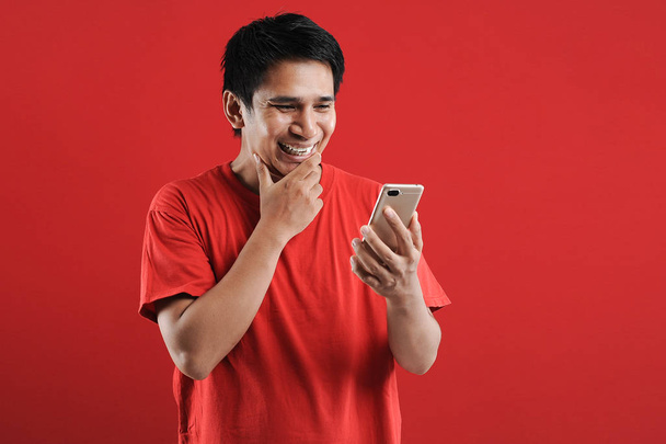 幸せなアジア人男性モバイル上の新しいテキストを読む - 写真・画像