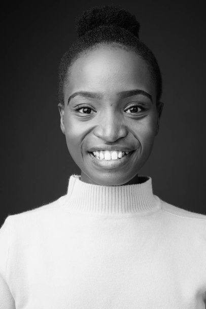 Студийный снимок молодой красивой африканской женщины зулу с афроволосами на сером фоне в черно-белом цвете - Фото, изображение