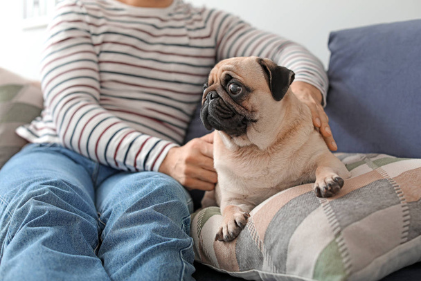 Handsome man with cute pug dog at home - Photo, Image
