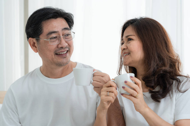 glückliches asiatisches Seniorenpaar, das gute Zeit zu Hause hat. Seniorenruhestand und gesundes Seniorenkonzept. - Foto, Bild