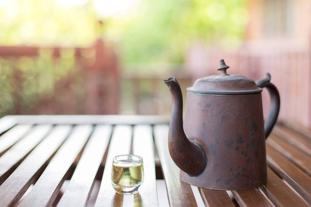 Conjunto de té de estilo asiático antiguo en una mesa de madera en un fondo borroso
 - Foto, Imagen