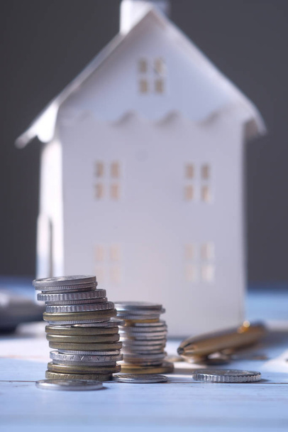concepto de financiación para el hogar con moneda y casa en la mesa
  - Foto, imagen