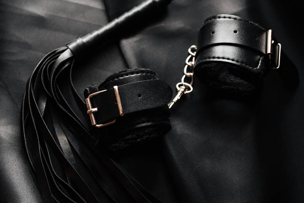 BDSM sex toys for domination and submission. Leather whip and handcuffs - Zdjęcie, obraz