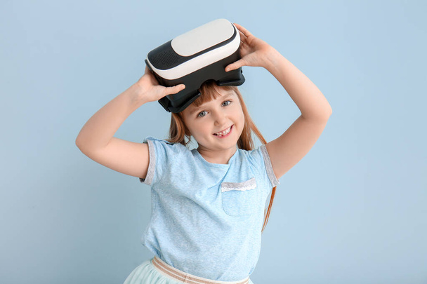 Κοριτσάκι με γυαλιά εικονικής πραγματικότητας στο φόντο χρώμα - Φωτογραφία, εικόνα