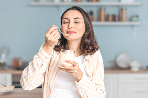 家でおいしいヨーグルトを食べる若い女性 - 写真・画像
