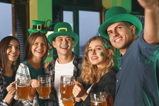 Young friends taking selfie during celebrating St. Patrick's Day in pub - Zdjęcie, obraz