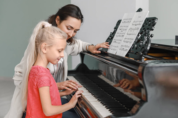 Insegnante di musica privata che dà lezioni di pianoforte alla bambina
 - Foto, immagini