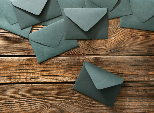 Бумажные конверты на деревянном фоне
 - Фото, изображение