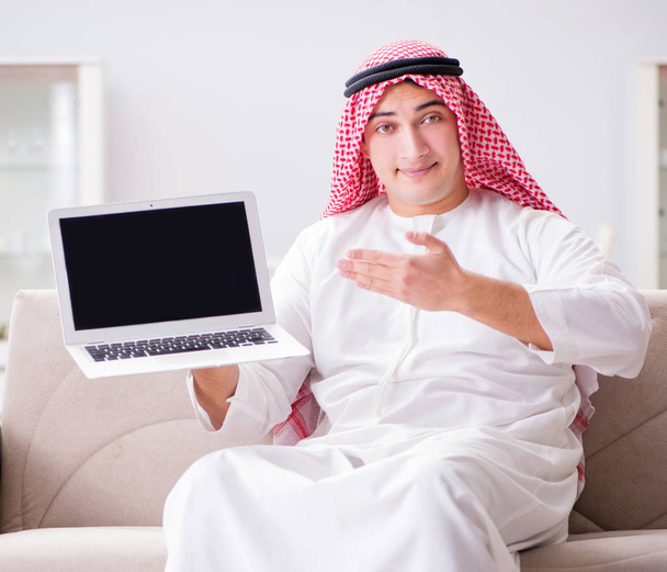 Hombre de negocios árabe joven que trabaja con el ordenador portátil en el sofá - Foto, Imagen
