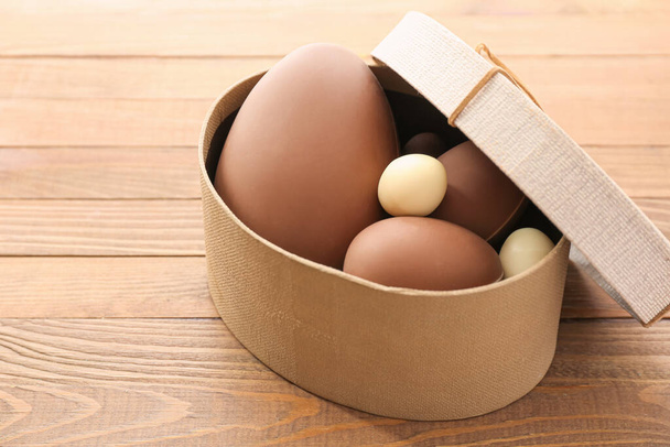 Lezzetli çikolatalı kutu Tahta arka planda Paskalya yumurtaları - Fotoğraf, Görsel