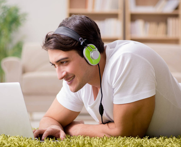 Young man listening to the music from laptop - Φωτογραφία, εικόνα