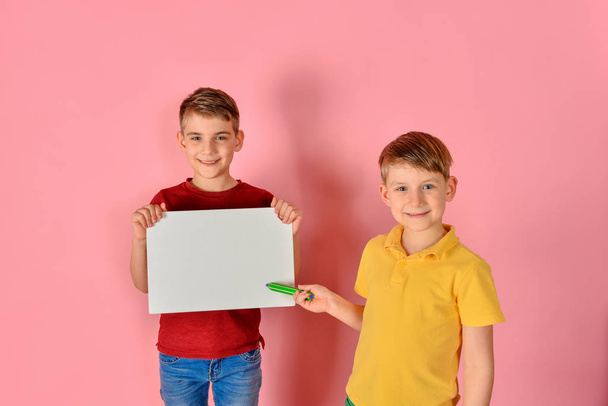 One boy holds a white board for inscription, the other shows a l - Foto, Bild