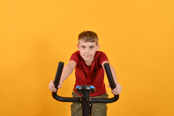 A gyermek megy a sport egy álló kerékpár, fitness gyerekeknek. - Fotó, kép