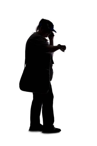 Silhouette of a curvy or plus size woman on a white background.  She is unrecognizable and using a cell phone or smartphone - Φωτογραφία, εικόνα