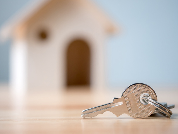 Hausschlüssel mit Holzhaus Hintergrund verschwommen, Immobilien-und Immobilieninvestitionen und Haus Hypothek Finanzkonzept - Foto, Bild