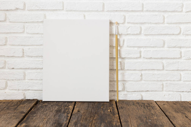 Cadre en toile blanche vide sur une table en bois
 - Photo, image