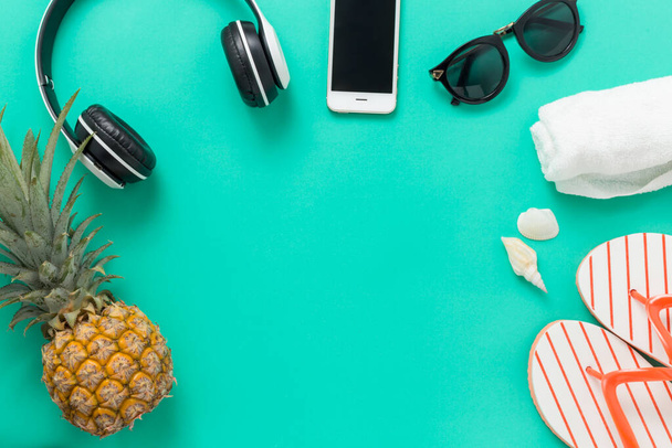 Фон Летние каникулы Концепция, телефон с ананасом, очки и шлепанцы На зеленом и желтом фоне вид сверху
 - Фото, изображение