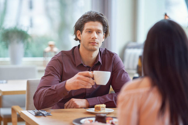 Casal jovem desfrutando de café e bolo no café
 - Foto, Imagem