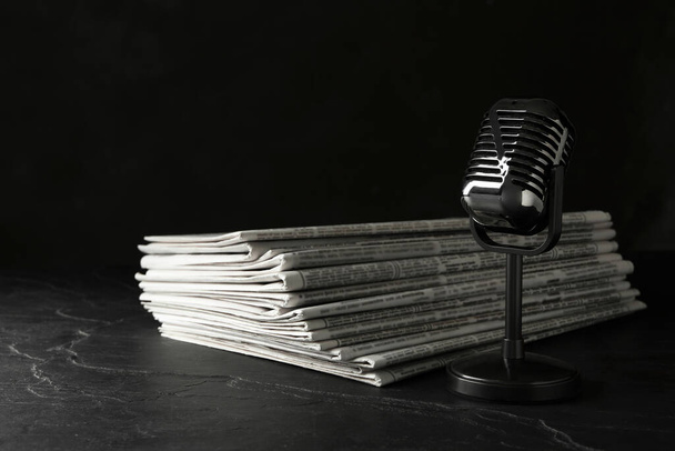Newspapers and vintage microphone on dark stone table. Journalis - Fotografie, Obrázek