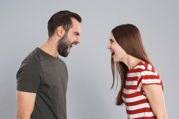 Couple quarreling on grey background. Relationship problems - Foto, Imagem