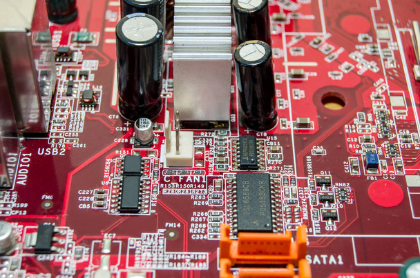 Красная материнская плата компьютера с микросхемой, крупным планом
 - Фото, изображение