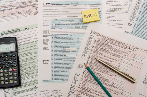 Formulaires d'impôt fédéral 1040 avec stylo, calculatrice et dollar
 - Photo, image