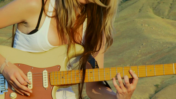 młoda kobieta piękna gra na gitarze na zewnątrz. gra na gitarze. - Materiał filmowy, wideo