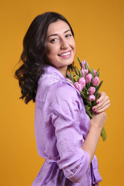 Beautiful female holding bouquet of springtime flowers for international women's day holiday. - Фото, зображення