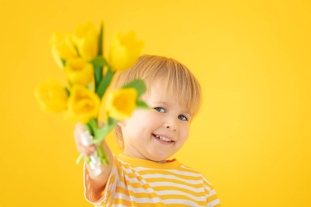 Happy child holding spring bouquet of flowers - 写真・画像