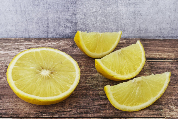 Кусочки лимона на деревянном столе
 - Фото, изображение