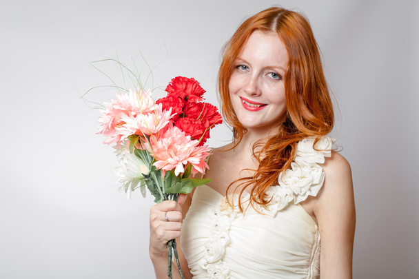 Beautiful redheaded girl with flowers studio shot - Zdjęcie, obraz