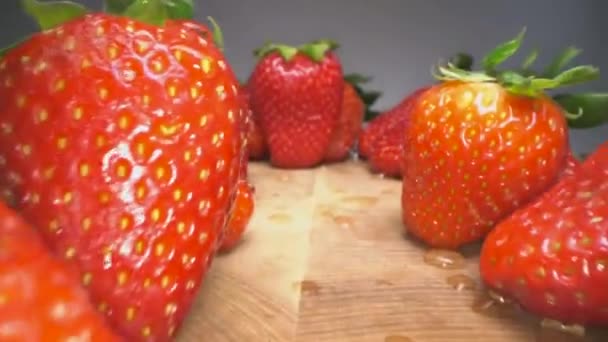 Dolly shot de fraises rouges juteuses sur fond de bois. Fond de fraise douce récoltée, mode de vie alimentaire sain
 - Séquence, vidéo