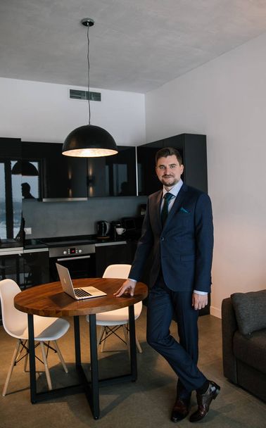 fashionably dressed businessman with a beard - stylish suit, brown shoes, tie, gloves, a man posing in an expensive apartment - Foto, immagini