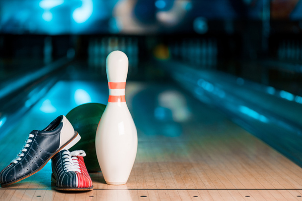 selective focus of bowling shoes, ball and skittle on bowling alley - Fotografie, Obrázek