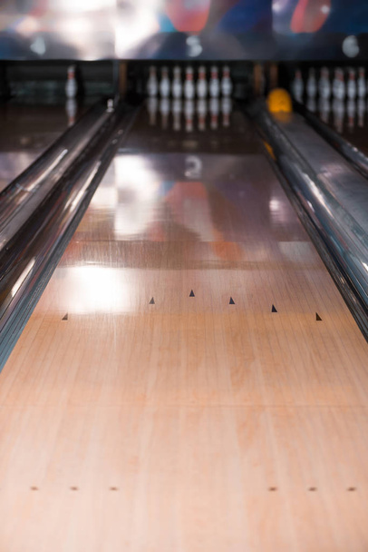 selective focus of skittle alley and skittles in bowling club - Foto, imagen