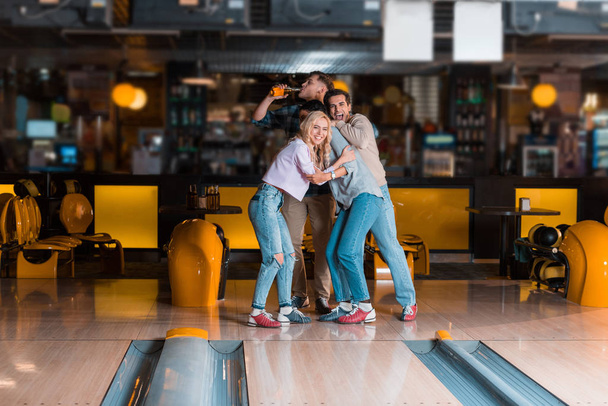 vzrušené přátelé při pohledu na kuželky při hraní bowling spolu - Fotografie, Obrázek