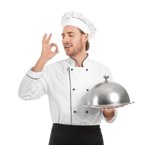 Glücklicher männlicher Koch mit Tablett und Cloche zeigt Ok-Geste auf weißem Hintergrund - Foto, Bild