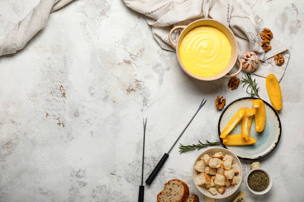 Fondue de queso con snacks sobre fondo gris
 - Foto, Imagen
