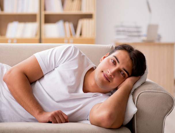 Молодий чоловік спить на дивані
 - Фото, зображення