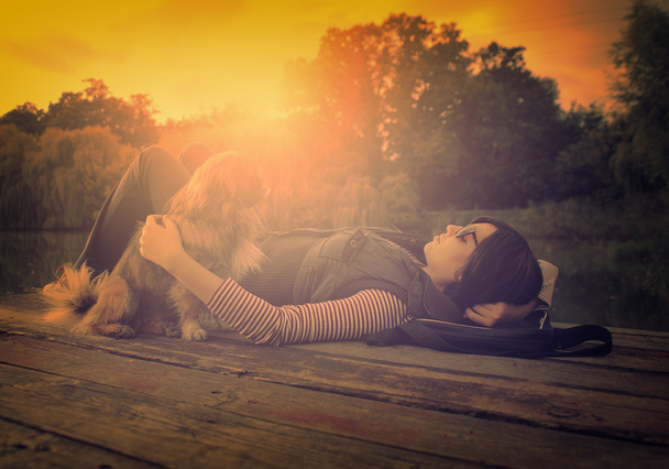 Photo vintage de femme relaxante avec son chien sur une jetée
 - Photo, image