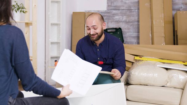 Jeune couple confus lors de l'assemblage de meubles dans leur appartement
 - Photo, image