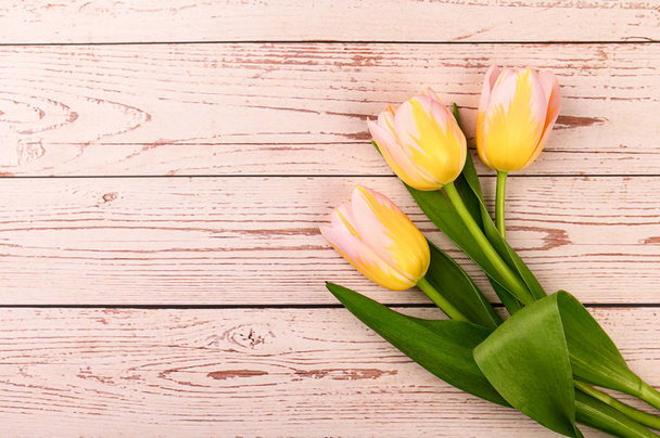 Fondo de primavera. Coloridos tulipanes florecientes sobre un fondo de madera. Copiar espacio
. - Foto, Imagen