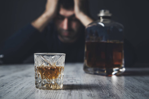 sad man hand in head with whiskey - Foto, Imagen